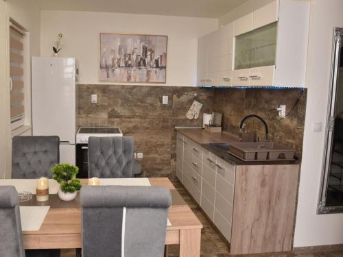 a kitchen with a sink and a table with chairs at Kuca za Odmor ISKRA in Mokra Gora