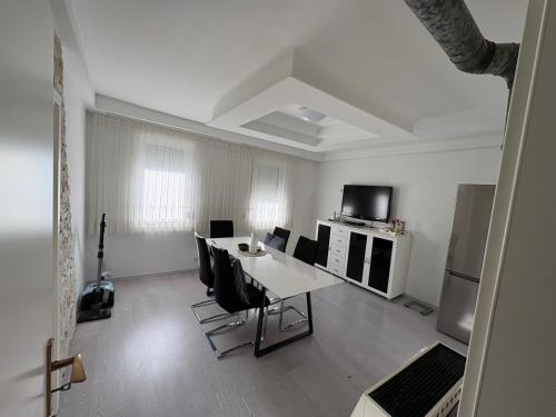a white living room with a table and chairs at HostelCetin in Göppingen