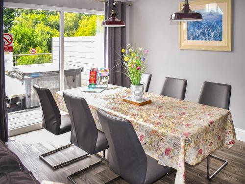a dining room with a table and chairs with flowers on it at Oak Park One - Uk50062 in Tiverton