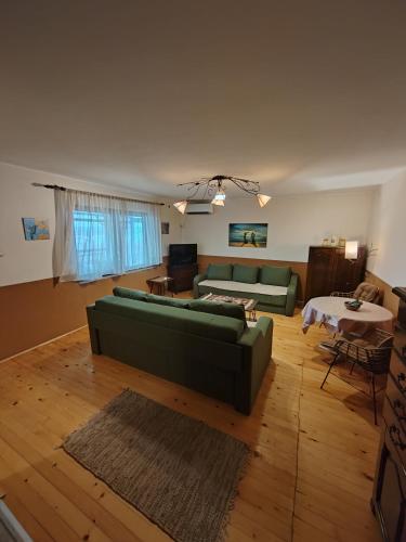 a living room with a green couch and a table at Weekendaya in Kladovo