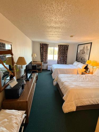 a hotel room with two beds and a television at Budget inn & Suites in De Witt