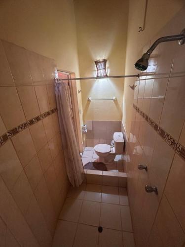 a small bathroom with a toilet and a shower at Punta Pacífico Bungalows Máncora in Máncora