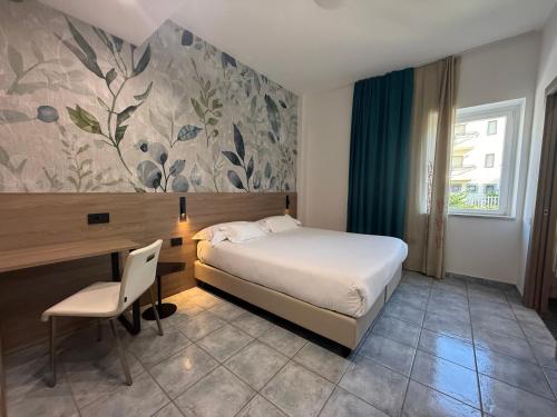 una camera da letto con un letto, una scrivania, un tavolo e una sedia di Hotel Maiuri Pompei a Pompei