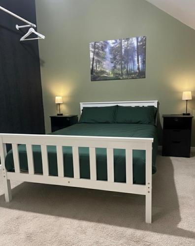 a bedroom with a white bed with green sheets at Entire 3 bedroom deluxe house in Cleckheaton
