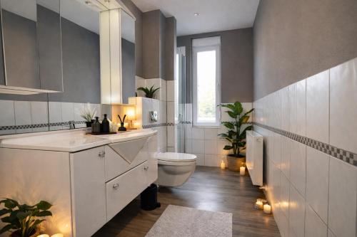 a white bathroom with a toilet and a window at Haus Gitta - Wohlfühlen & Genießen in Luckenwalde