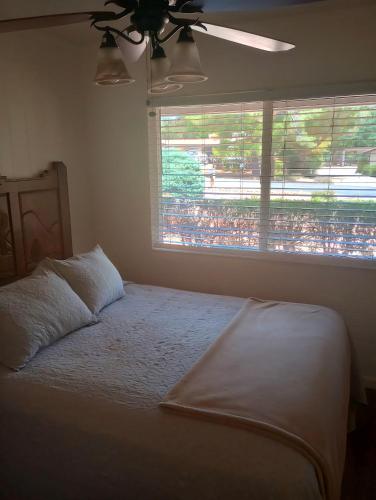 a bedroom with a bed with a ceiling fan and a window at Redrockescapes in Sedona