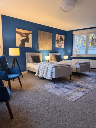a bedroom with two beds and a blue wall at Haus Gitta - Stilvolle Stadtoase in Luckenwalde