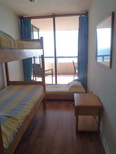 a bedroom with two bunk beds and a balcony at Club Playa Blanca in Playa Blanca