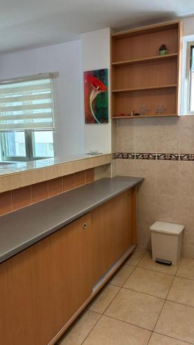 a large kitchen with a counter and a window at Apart Ludmila in Bečići
