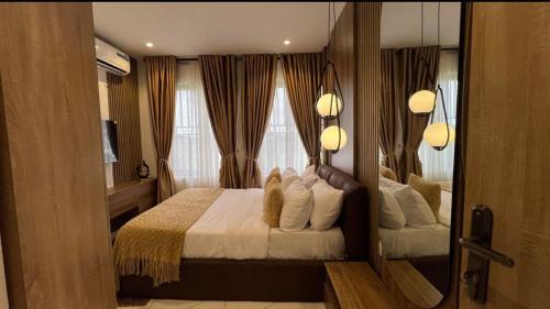 a bedroom with a large bed and a mirror at Luxury 3Bedroom Apartment in Sangotedo Ajah in Lekki
