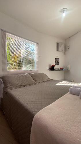 a bedroom with a large bed and a window at FamilySpace in Búzios
