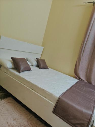 a bed with two pillows on it in a room at Tataicha Appart 3 in NʼDjamena