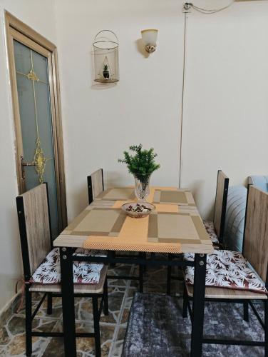 a dining room table with chairs and a vase on it at Tataicha Appart 3 in NʼDjamena