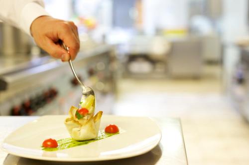 a person is eating food on a plate with a fork at Berghotel Tyrol in Senales