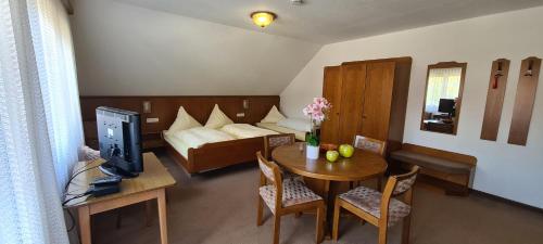 a small room with a bed and a table with a television at Pension Hauber - Kirchturmblick in Herrischried