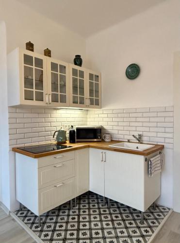 a kitchen with white cabinets and a sink at Panoráma apartmán Centrum in Banská Štiavnica
