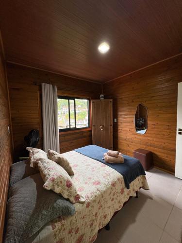 a bedroom with a bed in a wooden room at Cobertura Vista mar com churrasqueira in Governador Celso Ramos