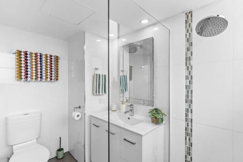a white bathroom with a toilet and a sink at Riverview Sanctuary - Walk to CBD & South Bank in Brisbane