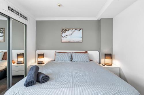 a white bedroom with a large bed with two lamps at Riverview Sanctuary - Walk to CBD & South Bank in Brisbane