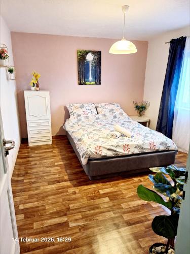 a bedroom with a bed and a wooden floor at Rural accommodation Vidovic in Ugarci