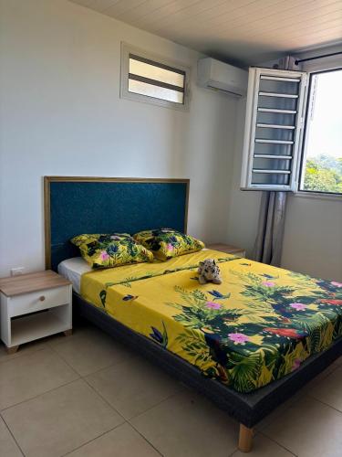 a bedroom with a bed with a yellow comforter at Residence la Floride in Gros-Morne