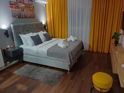 a bedroom with a large bed and a yellow curtain at The Little Haven in Kragujevac