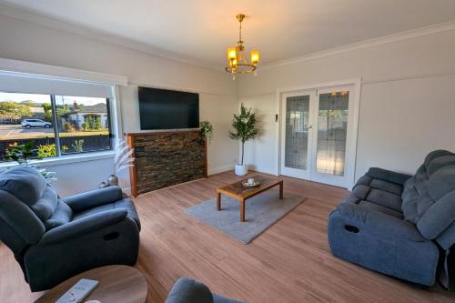 a living room with two couches and a tv at Home in Moe in Moe