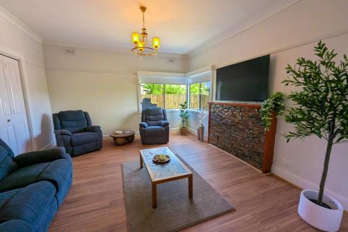 a living room with a blue couch and a tv at Home in Moe in Moe