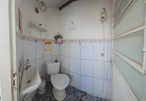 a small bathroom with a toilet and a sink at Quarto Aconchegante com Wi-Fi self check-in e garagem in Pouso Alegre