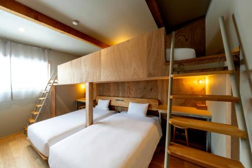 two beds in a room with two bunk beds at B and D HAKUBA IWATAKE in Hakuba