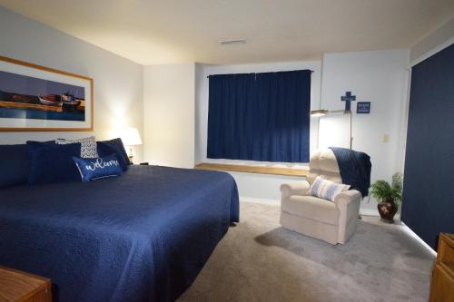 a bedroom with a bed and a chair and a window at Grant's Condo in The Greens in Branson