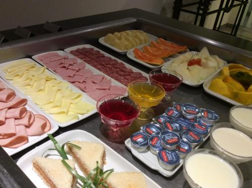 a buffet of different types of cheese and other foods at Mara Turismo Hotel in Catalão