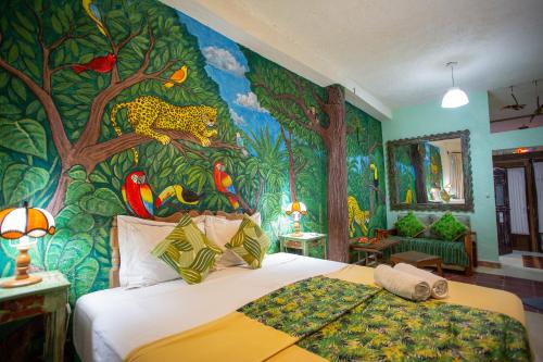 a bedroom with a wall mural of a jungle at La Selva by Majikal B&B in Mérida