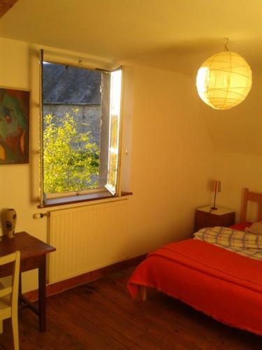 a bedroom with a red bed and a window at 4 Joliette in Tartiers