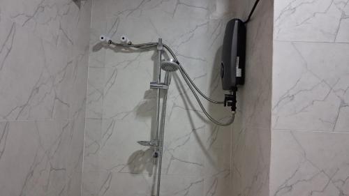 a shower with a phone in a bathroom at Layans Properties in Gampaha
