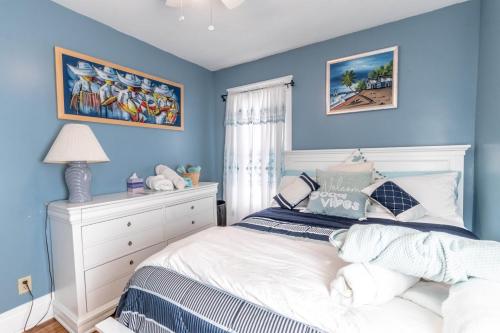 a bedroom with blue walls and a white bed at The Paradise House steps from the Heart of Hertel in Buffalo