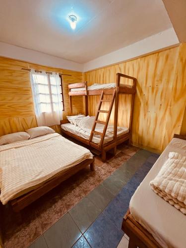 a bedroom with two bunk beds and a window at Mama Lourdes Homestay in Sagada