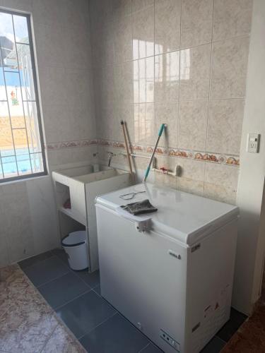 a bathroom with a white refrigerator and a toilet at Villa Alejandro in Melgar