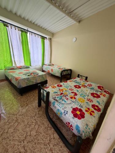 a bedroom with two beds and two chairs in it at Villa Alejandro in Melgar