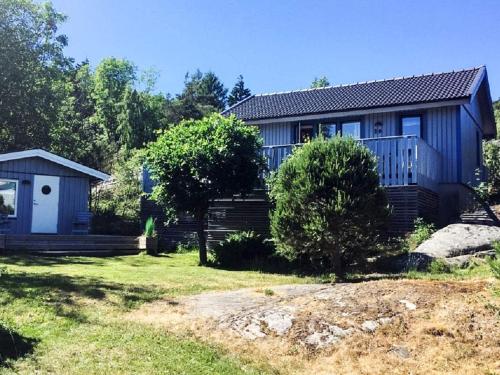 a house with a porch and a yard with a house at 4 person holiday home in Nordkoster in Strömstad