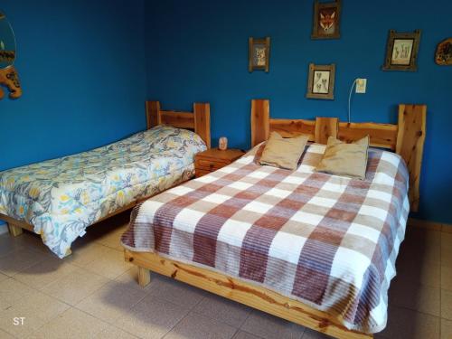 a bedroom with two beds and a blue wall at Cabaña azul in Los Antiguos