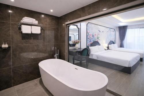 a bathroom with a bath tub and a bedroom at Stella De Boutique Hotel in Sapa