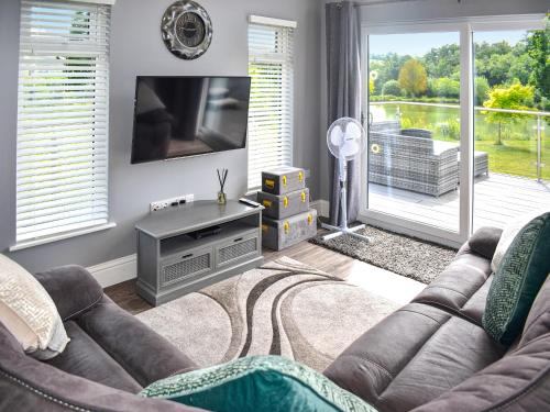 a living room with a couch and a television at Oak Park Two - Uk50063 in Tiverton