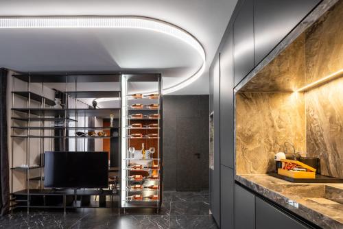 una cucina con una grande dispensa in vetro e un televisore di Ruby Apartment Ks a Pristina