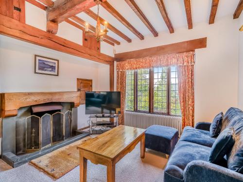 a living room with a fireplace and a tv at High Biggin in Windermere