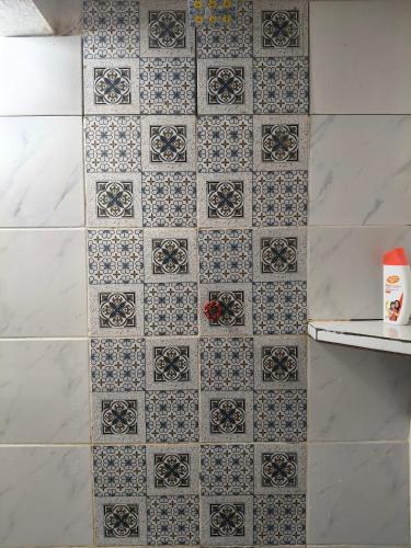 a bathroom with a blue and white tile wall at Halwa Homestay in Semporna
