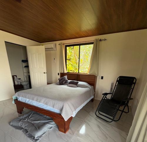 a bedroom with a large bed and a window at Cabin Casove in El Castillo de La Fortuna