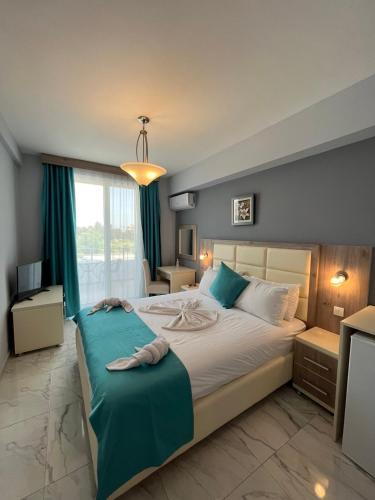 a bedroom with a large bed with a blue blanket at Bilali Apartments in Ulcinj