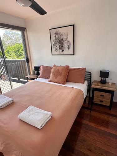 a bedroom with a large bed with two pillows on it at Boongala - Central 3BR pet friendly family home in Maroochydore