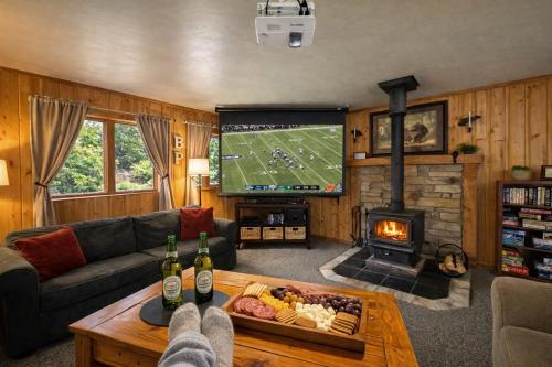 a living room with a football game on the tv at Bear Paw Cabin in Leavenworth